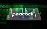 Peacock logo on a phone sitting on a keyboard