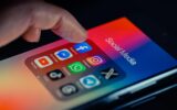 finger pointing to Facebook mobile app displayed on a smartphone screen