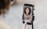 woman recording a video on her phone in selfie mode, to illustrate filming an unlockable reel on Instagram
